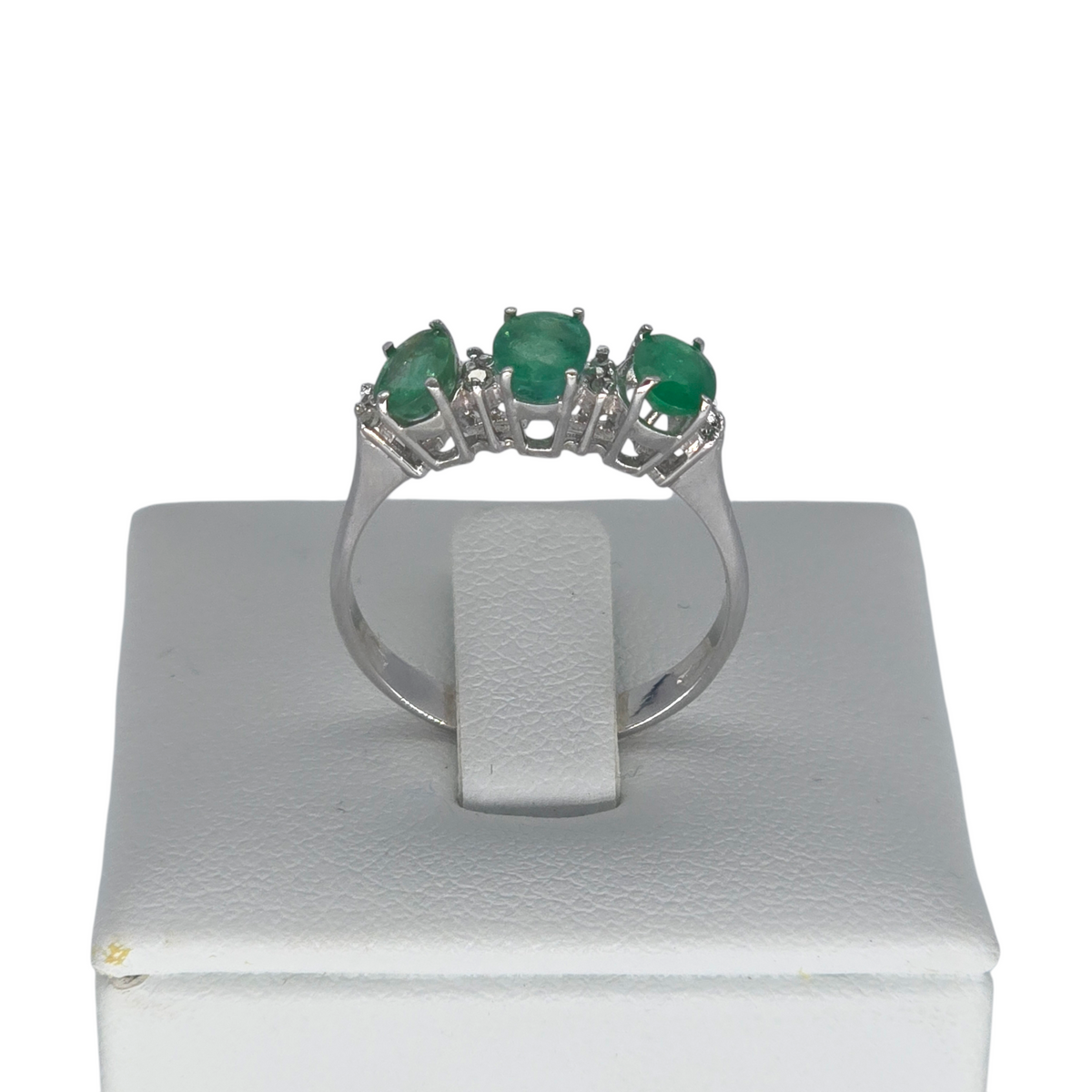 Anello Trilogy Smeraldi e Diamanti Oro Bianco 18kt - vista frontale su espositore