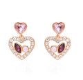 Orecchini pendenti in metallo rosato forma cuore con pietre rosa e strass